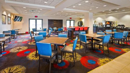 a restaurant with tables and chairs in a cafeteria at Comfort Inn Saint Paul East in Oakdale