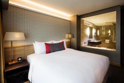 
a hotel room with a large bed and a large mirror at Grand Mercure Singapore Roxy - SG Clean in Singapore
