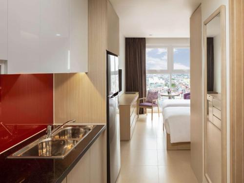 a kitchen with a sink and a view of a room at Mercure Hai Phong in Hai Phong