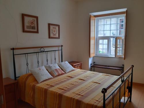 a bedroom with a bed and a window at Casa do Pelourinho in Vouzela