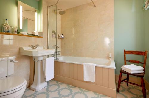 a bathroom with a tub and a sink and a toilet at The Greyhound Inn in Wantage