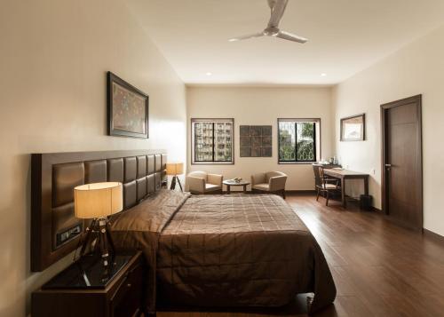 een slaapkamer met een groot bed en een bureau bij Park Suites in Calcutta