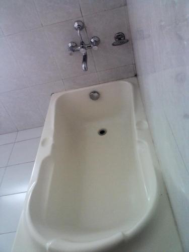 a white bath tub with a faucet in a bathroom at Hotel Yambu kathmandu in Kathmandu