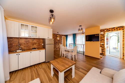 a kitchen and living room with white cabinets and a table at Apartments Sole Mar in Sutomore