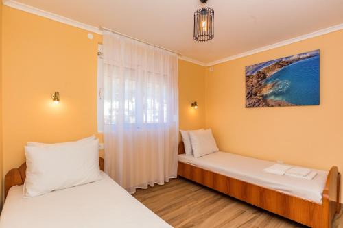 a bedroom with two beds and a window at Apartments Sole Mar in Sutomore