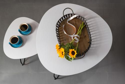 a table with a plate with flowers and two cups of coffee at Marvarit Suites in Mesaria