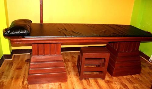 a bed in a room with a wooden floor at Nepal Ayurveda Home in Kathmandu