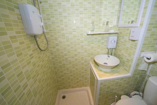 a small bathroom with a toilet and a sink at Pebble Cottage in Holt