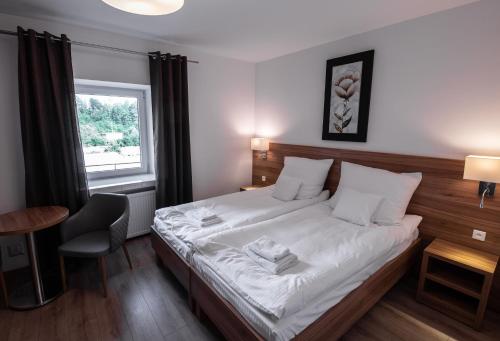 a bedroom with a bed and a desk and a window at Apartamenty ZYGFRYD 28C 3 6 in Bystrzyca Kłodzka