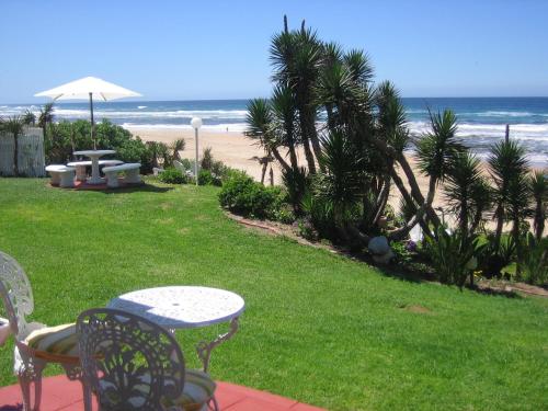 a patio with a table and chairs and the beach at Haus am Strand - on the Beach in Wilderness