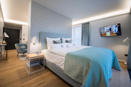 a bedroom with a large bed and a tv on the wall at Gut Kump Gastronomie und Hotel in Hamm