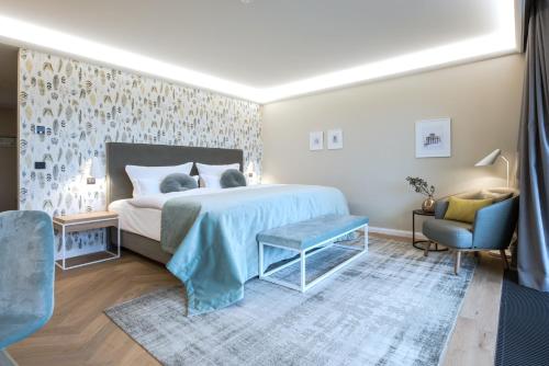 a bedroom with a bed and a blue chair at Gut Kump Gastronomie und Hotel in Hamm