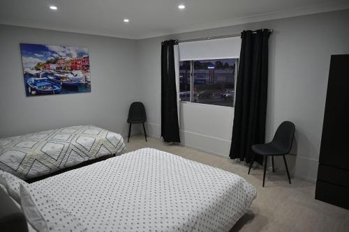 1 dormitorio con 1 cama, ventana y sillas en Bowman's Place, en Guildford