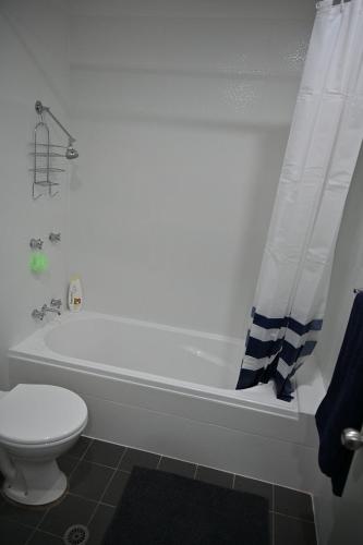 y baño con bañera blanca y aseo. en Bowman's Place, en Guildford