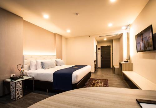 a hotel room with a large bed and a hallway at Alfahad Hotel in Hat Yai