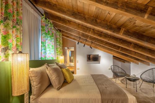 a bedroom with a large bed and wooden ceilings at Ivoni Villa, an Iconic Summer Retreat, By ThinkVilla in Perama