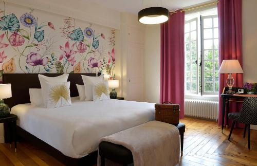 1 dormitorio con 1 cama blanca grande y papel pintado con motivos florales en Château Saint Gilles, en Guéron