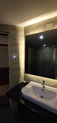 a bathroom with a white sink and a mirror at Hotel Sri Ram Residency in Udupi