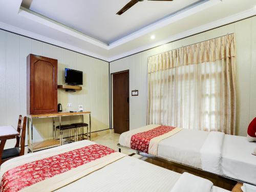 a hotel room with two beds and a window at Hotel Wildlife Camp in Sauraha