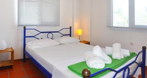 1 dormitorio con 1 cama con sábanas blancas y toallas en Village Holiday House Nick, en Agia Paraskevi