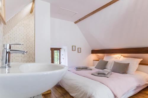 uma casa de banho com uma cama, um lavatório e uma banheira em Domaine du Manoir de Vains em Vains