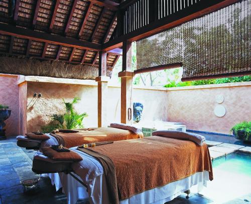 two beds in a room with a pool at The Oberoi Beach Resort, Mauritius in Balaclava