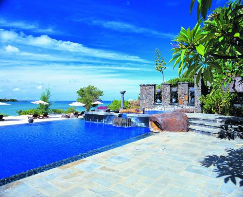 a swimming pool with the ocean in the background at The Oberoi Beach Resort, Mauritius in Balaclava