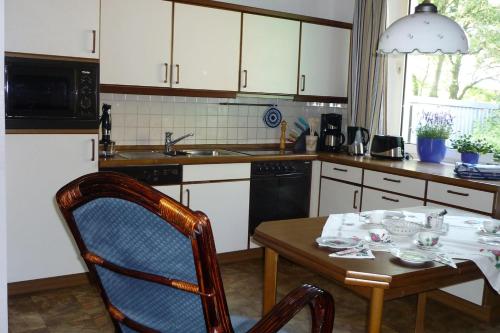 a kitchen with a wooden table and a table and chairs at Deichhof in Westoverledingen