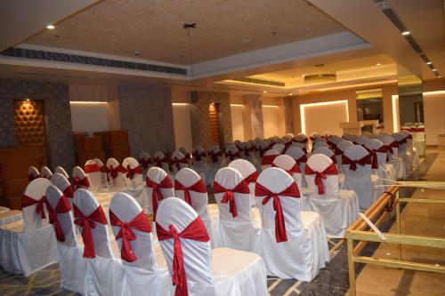 a room with white tables and chairs with red bows at Hotel Deep Clarks Inn Lucknow in Lucknow