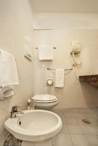 a bathroom with a toilet and a sink and towels at Hotel Costantini in Florence