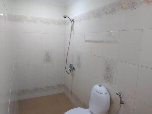 a bathroom with a toilet and a shower at Hotel Thushara in Kovalam