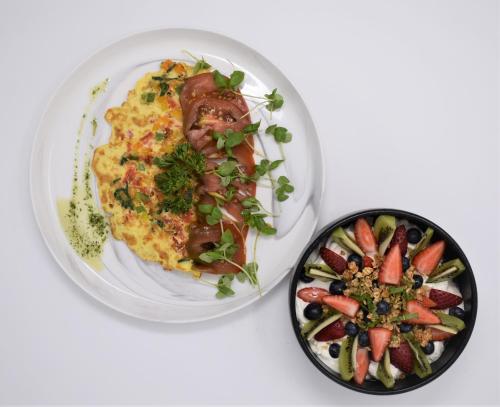 a plate with a omelet and a bowl of fruit at YO1 Longevity & Health Resorts, Catskills in Monticello