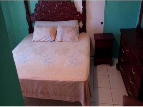 a bedroom with a bed with white sheets and pillows at Reggae Moon Guesthouse in Falmouth