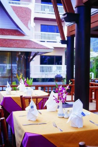 two tables with purple table cloths and vases with flowers at Kata Poolside Resort SHA Extra Plus in Kata Beach