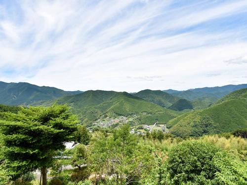 a view of a valley with mountains and trees at Kirinosato Takahara in Tanabe