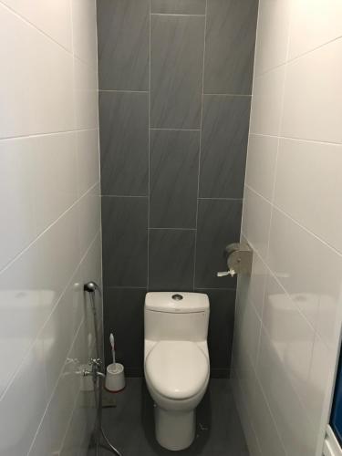 a bathroom with a white toilet in a stall at Landed Cozy House Near SPICE, Airport in Kampong Manggis