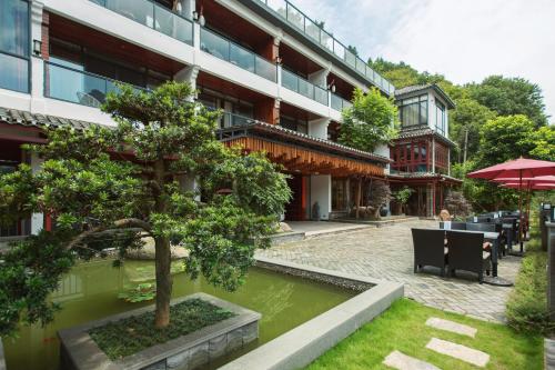 Li River Resort في يانغتشو: مبنى فيه شجرة امام ساحة الفناء