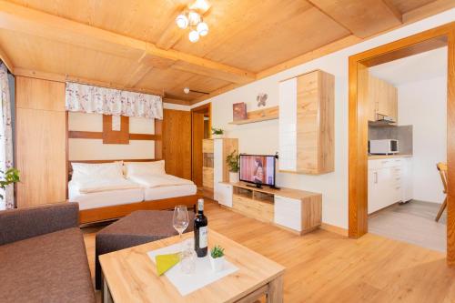 a living room with a couch and a bed and a television at Rainberghof in Rauris