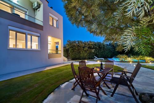 a patio with a table and chairs in a yard at Villa Harma-Exopolis in Georgioupolis