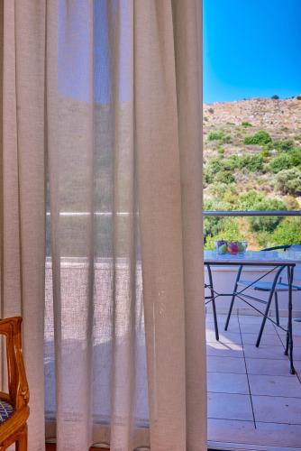 a view of a patio with a table and a curtain at Villa Harma-Exopolis in Georgioupolis