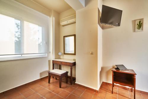 a room with a desk and a tv on a wall at Villa Harma-Exopolis in Georgioupolis