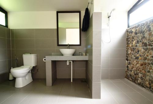 La salle de bains est pourvue d'un lavabo, de toilettes et d'un miroir. dans l'établissement Mulu National Park, à Mulu