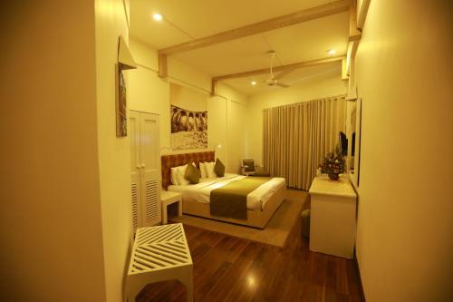 a bedroom with a bed and a room with a table at Orient Hotel in Bandarawela