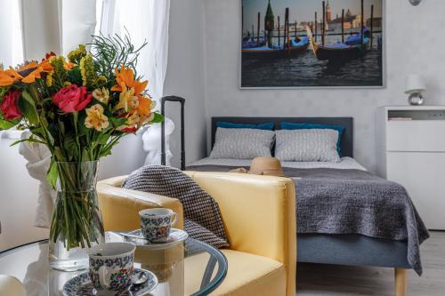 una sala de estar con una mesa con un jarrón de flores en Apartament w centrum Starówki Old Town, en Gdansk