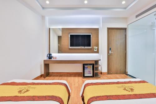 a hotel room with a bed and a flat screen tv at Prague Saigon Airport Hotel in Ho Chi Minh City