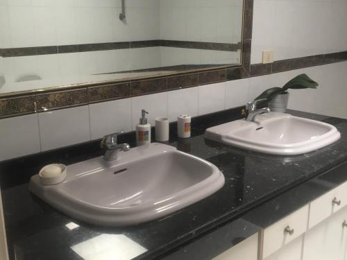 a bathroom counter with two sinks and a mirror at Mi casa in Puerto del Rosario