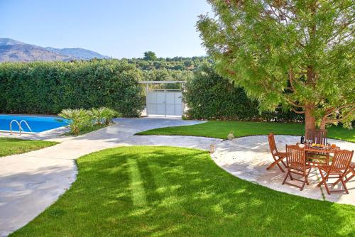 a patio with a table and chairs in a yard at Villa Harma-Exopolis in Georgioupolis