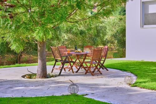 a table and chairs under a tree in a yard at Villa Harma-Exopolis in Georgioupolis