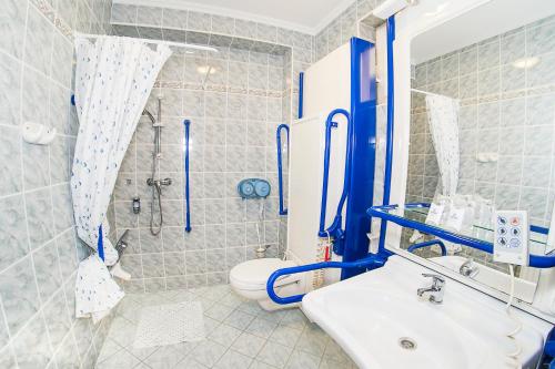 a bathroom with a sink and a shower and a toilet at Hotel Silver in Hajdúszoboszló