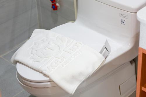 un asciugamano bianco, poggiato su un WC in bagno di Prague Saigon Airport Hotel ad Ho Chi Minh